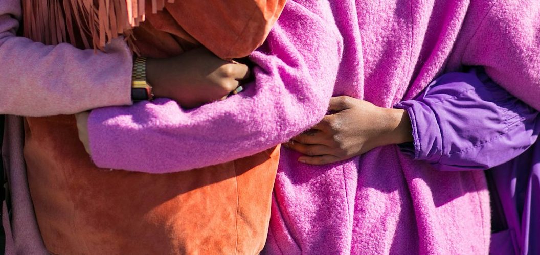 2 people with arms wrapped around each other.