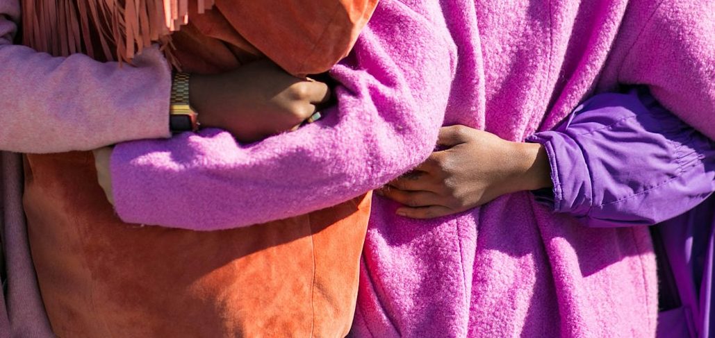 2 people with arms wrapped around each other.